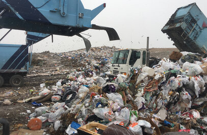 Vrachtwagens die afval dumpen op een stortplaats.