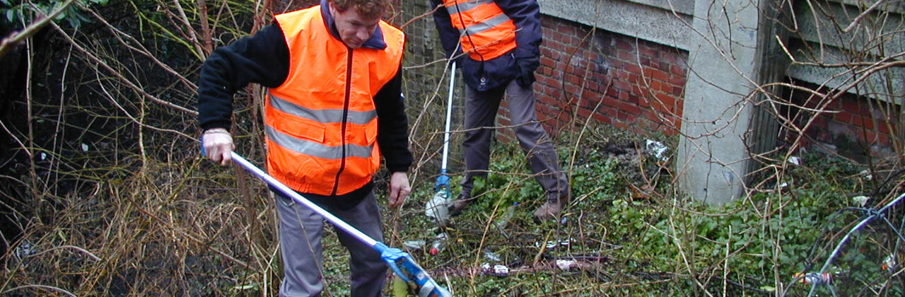 Twee mensen die afval opruimen.