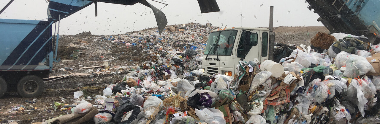 Vrachtwagens die afval dumpen op een stortplaats.
